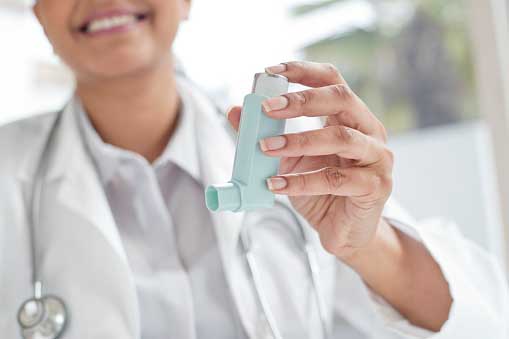 smiling doctor with inhaler in her hand